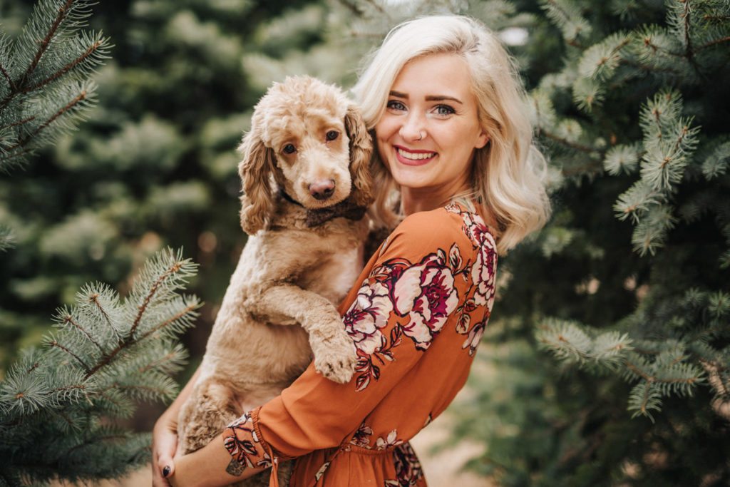 woman in orange dress holding pet dog